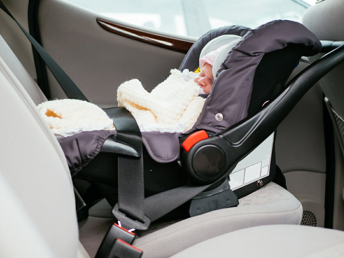 車で寝る帽子をかぶった赤ちゃん