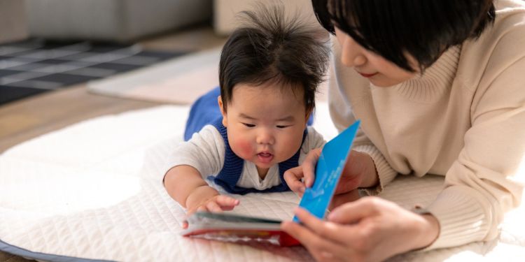 お母さんと絵本で遊ぶ赤ちゃん