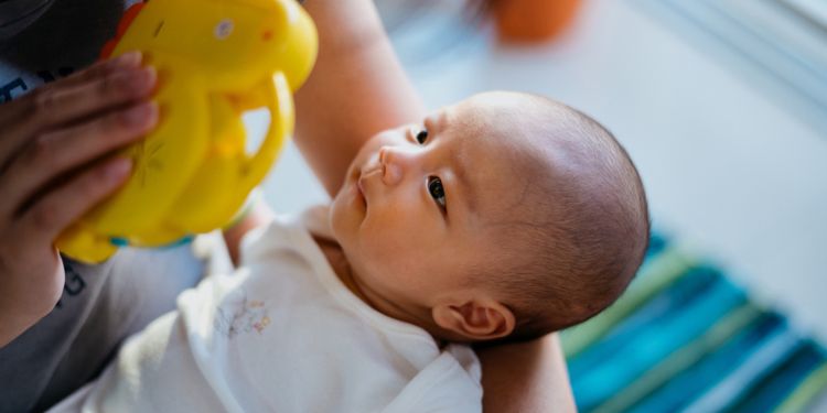 お母さんが持っているおもちゃを見つめる赤ちゃん
