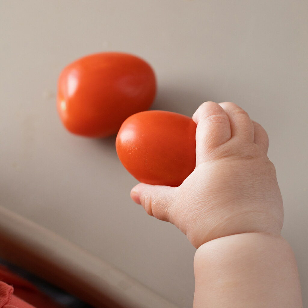 赤ちゃんの手とトマト