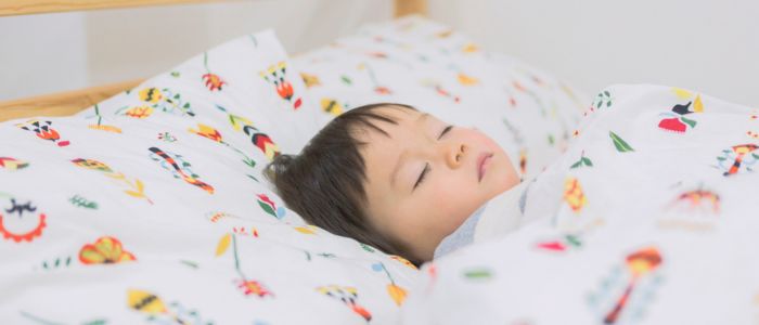明るい部屋で寝ている子どものイメージ