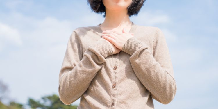 胸に手を当てる女性