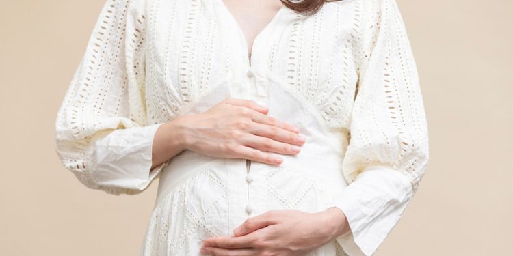 妊婦が自分のお腹を腕で包み込んでいる様子
