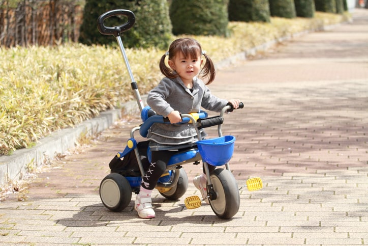 公園で三輪車に乗る子ども