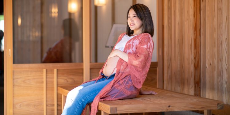 ベンチに腰掛ける妊婦