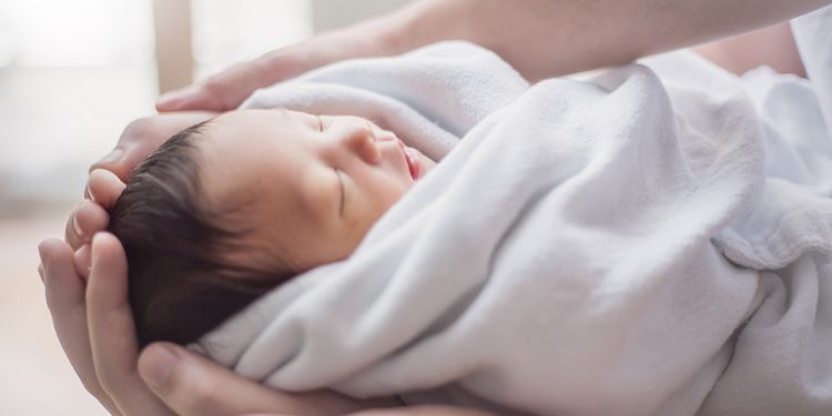 おくるみに包まれている赤ちゃんの画像