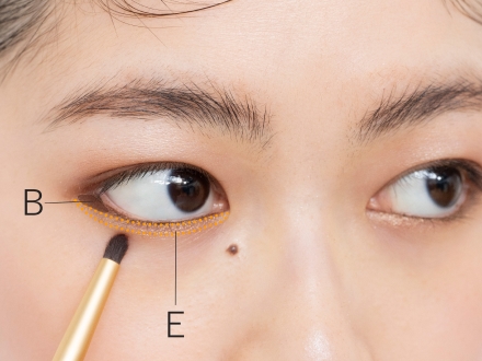 下まぶたの際にゴールドEを細めのブラシで入れ、目尻はBを重ねて締めます。