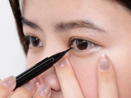 切開ラインには、ペン先が細く繊細なラインが描け、くっきり発色するアイライナーを選んで。黒のリキッドライナー②でまず目頭を囲むくの字に、まつ毛の際に重ねるようにラインを入れます。下まぶたは5mm程度まででとめます。